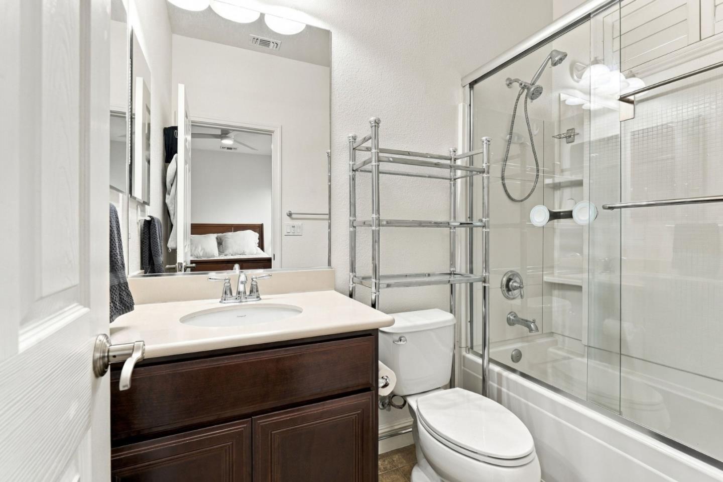 Bathroom with a dark wood vanity and glass-enclosed tub and shower.