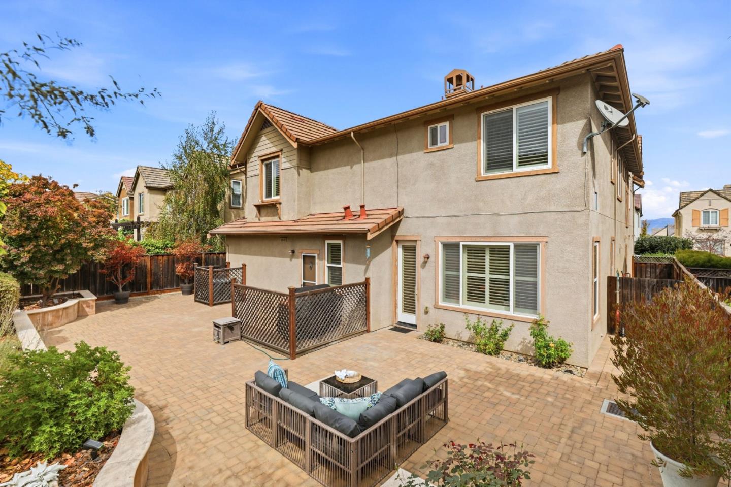 Two-story home with a spacious paved backyard patio and fenced outdoor seating area.