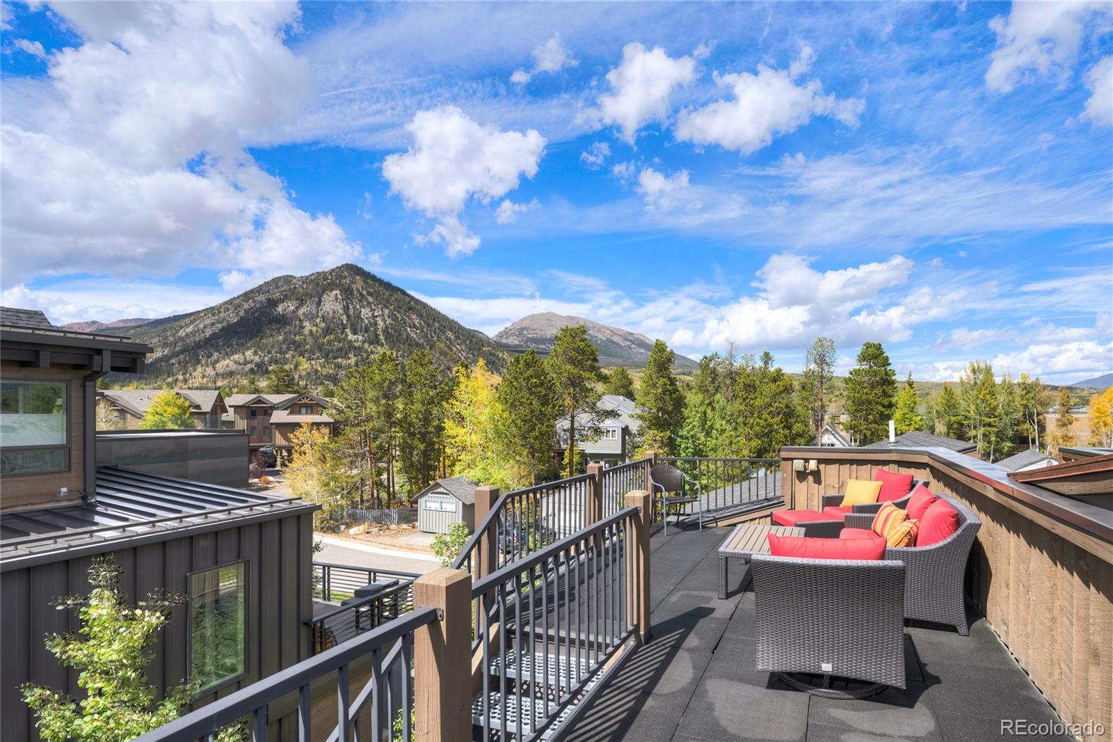 Rooftop deck with colorful outdoor seating and mountain views.