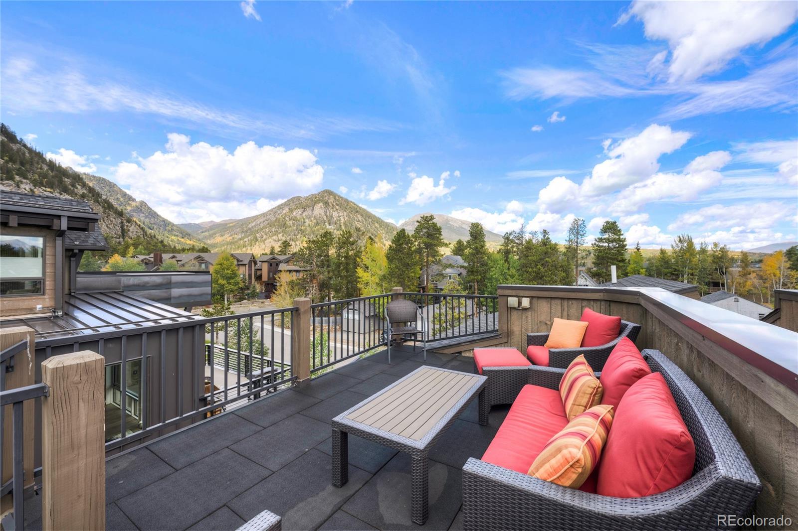 Rooftop deck with red-cushioned seating and mountain views in Frisco.