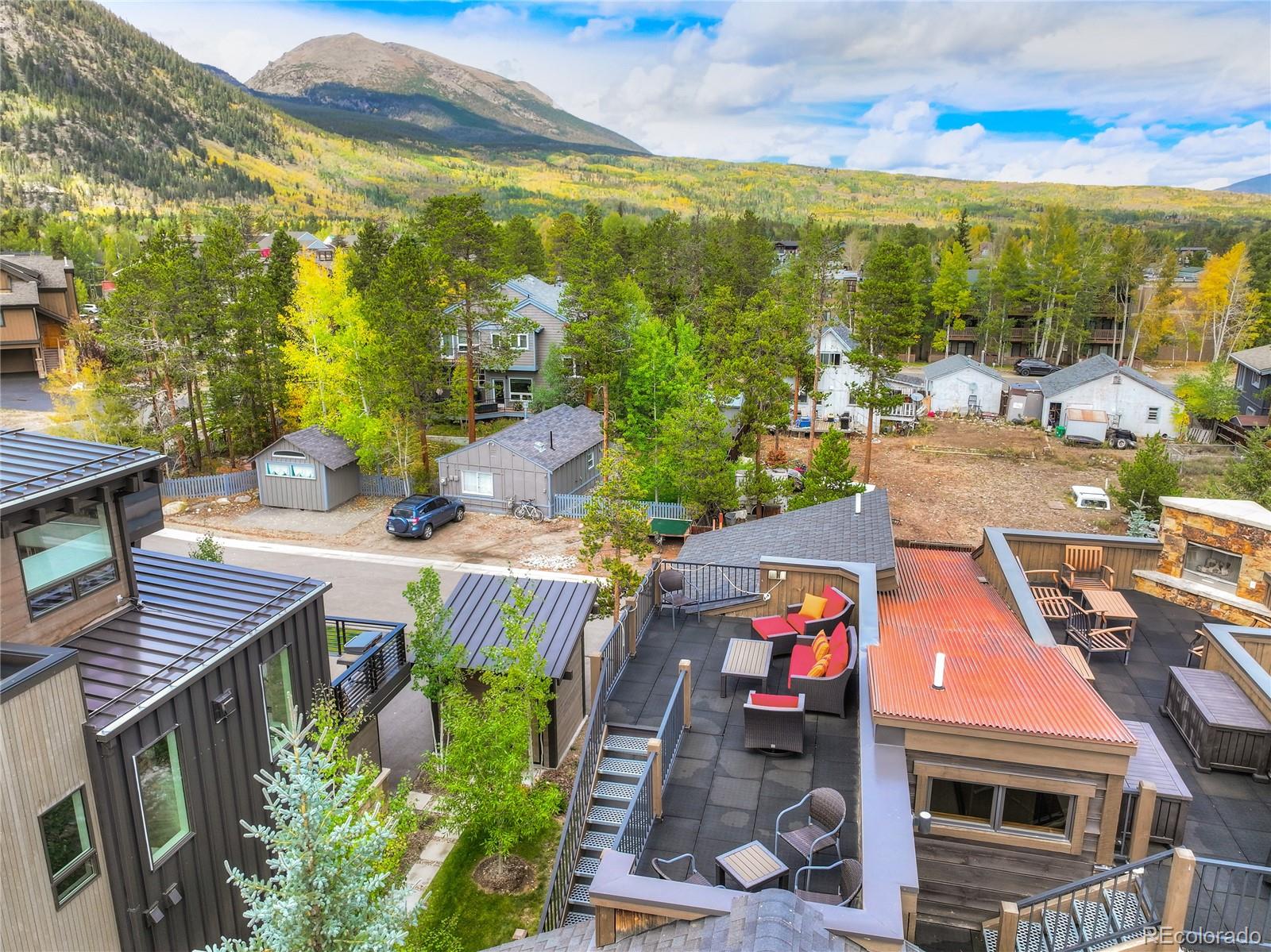 Furnished rooftop terrace overlooks Frisco homes and colorful autumn mountains.