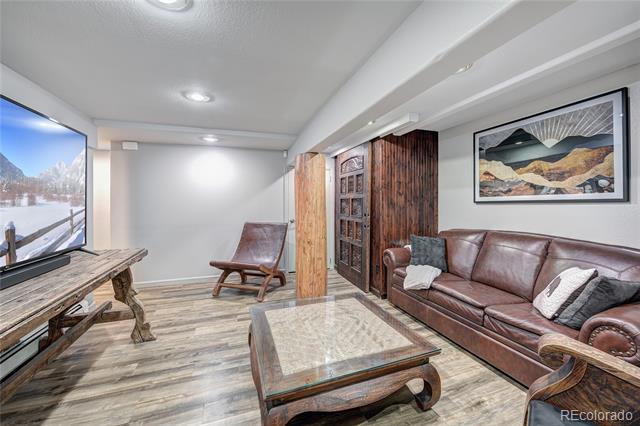 Living room with a brown leather sofa, rustic wood cabinetry, and a glass-topped coffee table.