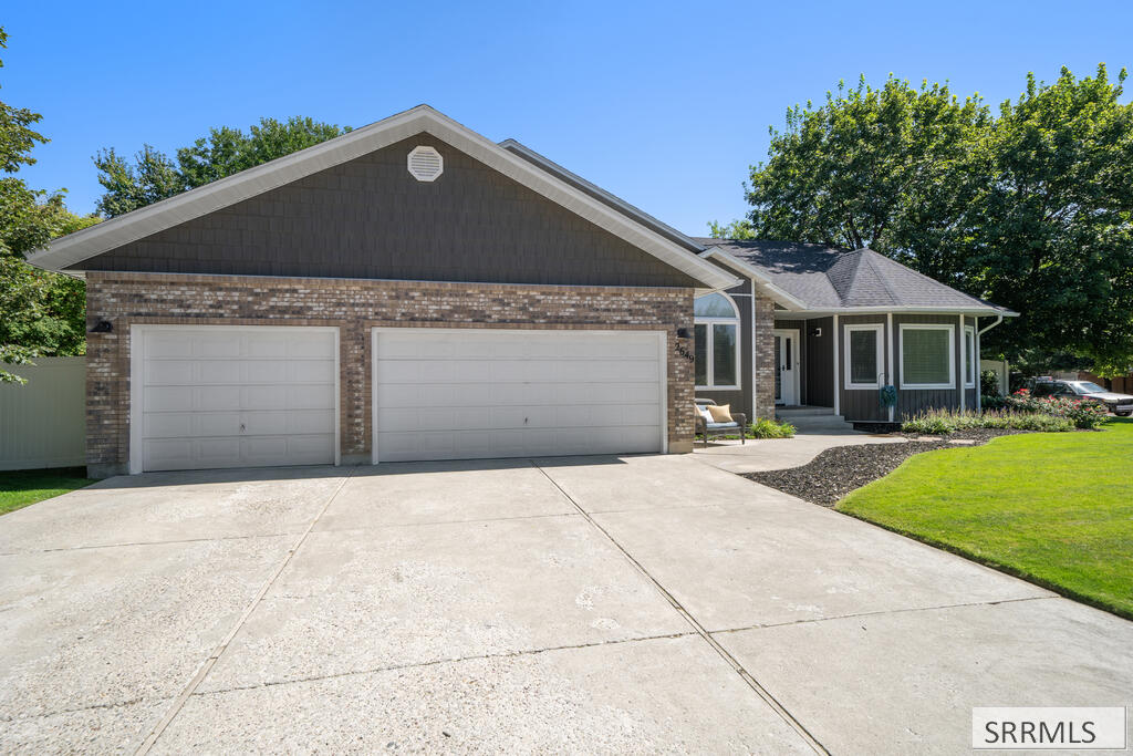 Single-story brick home with an attached two-car garage and wide concrete driveway.