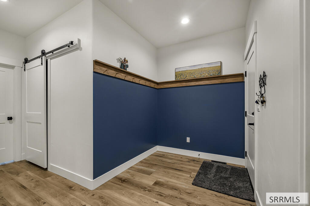 Room with navy blue walls, wood trim ledge, and sliding barn door.