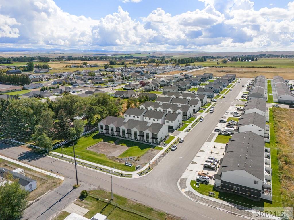Aerial view of a residential neighborhood with rows of homes beside open farmland.