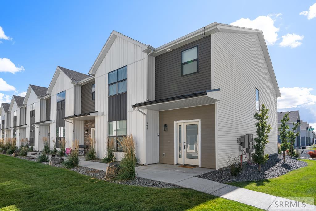 Modern two-story townhomes with contrasting siding and landscaped front lawns.