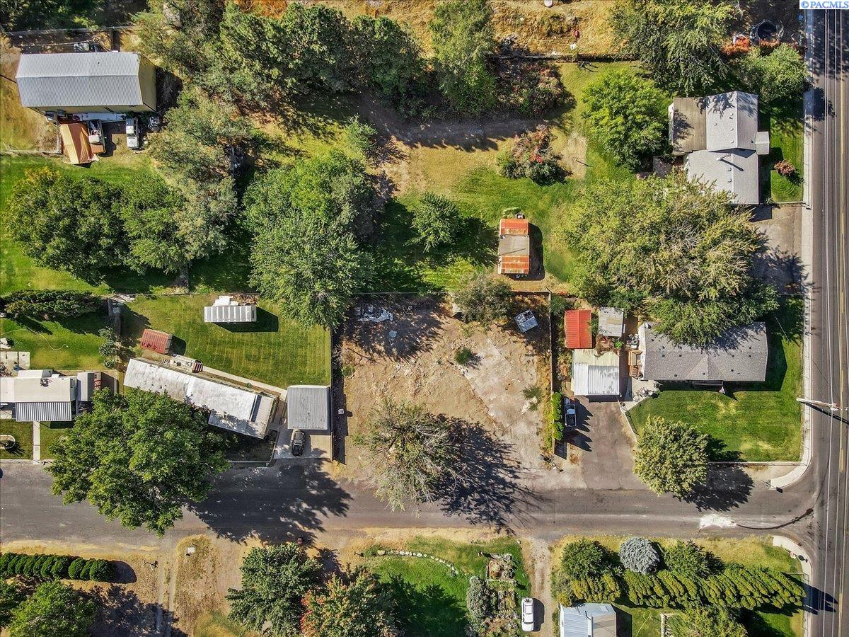 Aerial view of a mostly cleared residential lot surrounded by trees, homes, and streets.