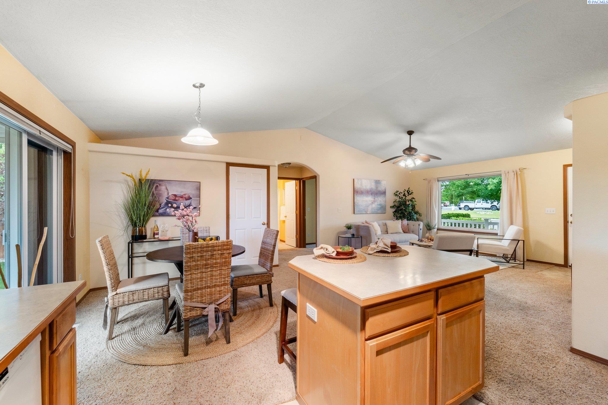 Open-plan kitchen and living area with a large wood island and dining table.