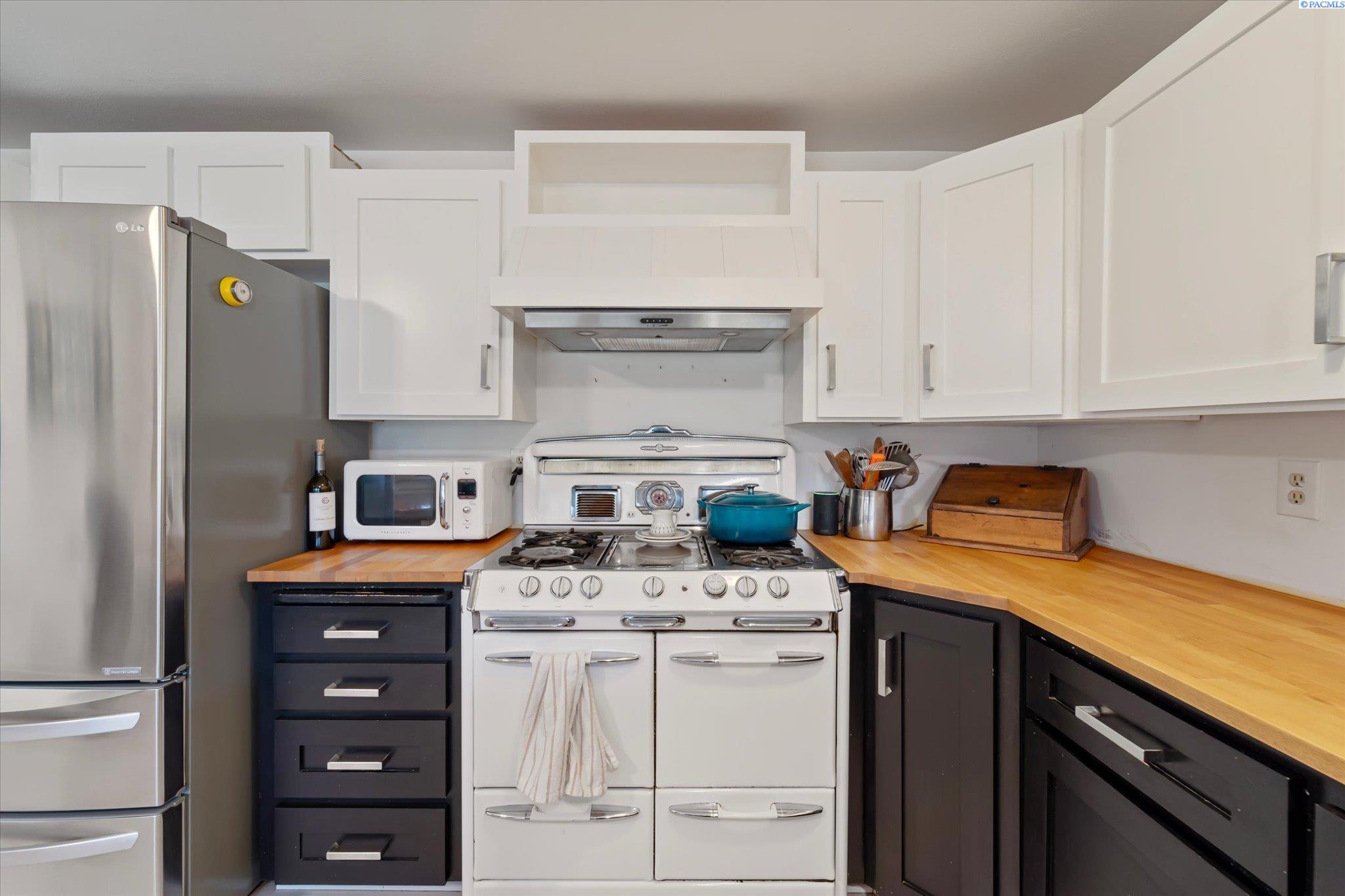 Kitchen with butcher-block counters, dark lower cabinets, and a white vintage-style range.