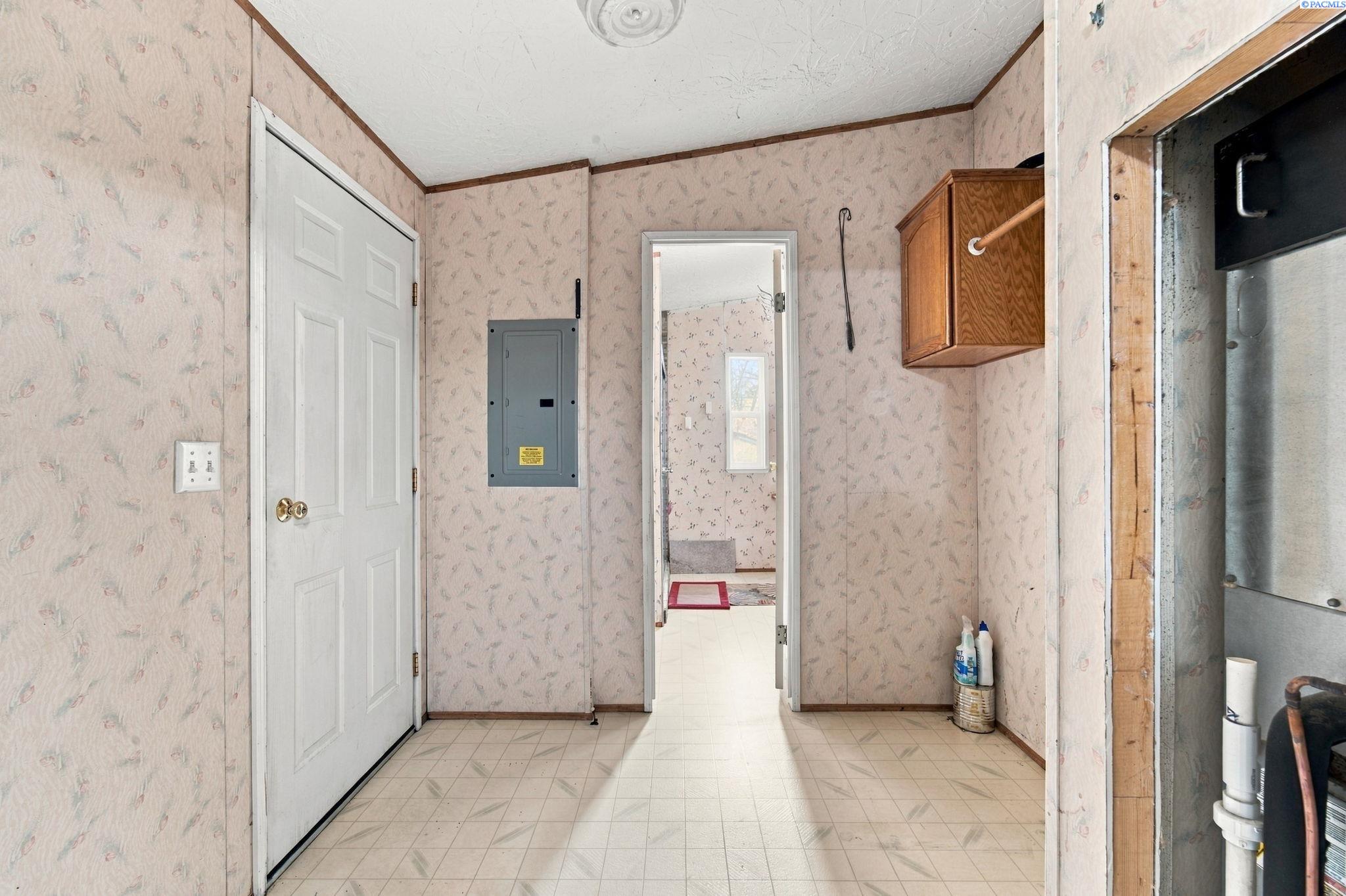 Utility room with tiled floor, electrical panel, and wall cabinet.