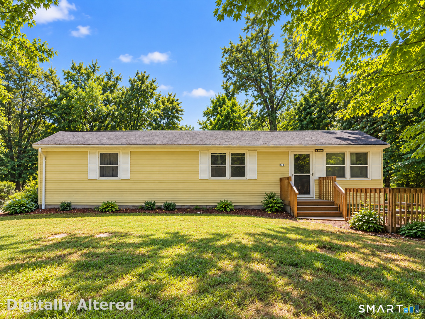 Yellow ranch-style home with a wooden porch and deck, mature trees, and a broad front lawn.