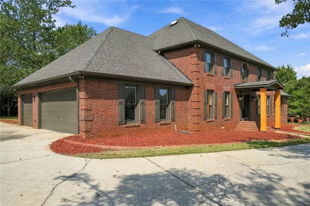 Two-story red brick house with an attached double garage and covered front entry.