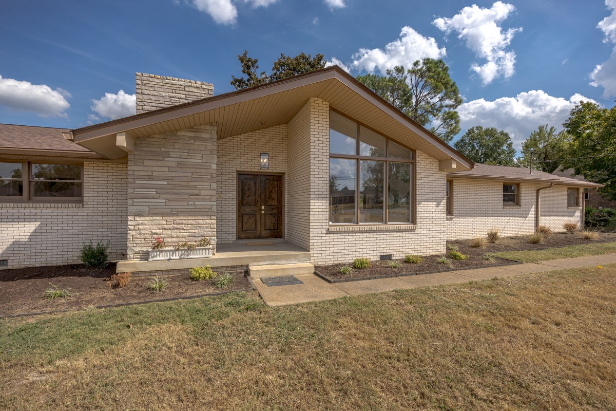Brick home with a gabled entry, stone facade accent, and tall front windows.