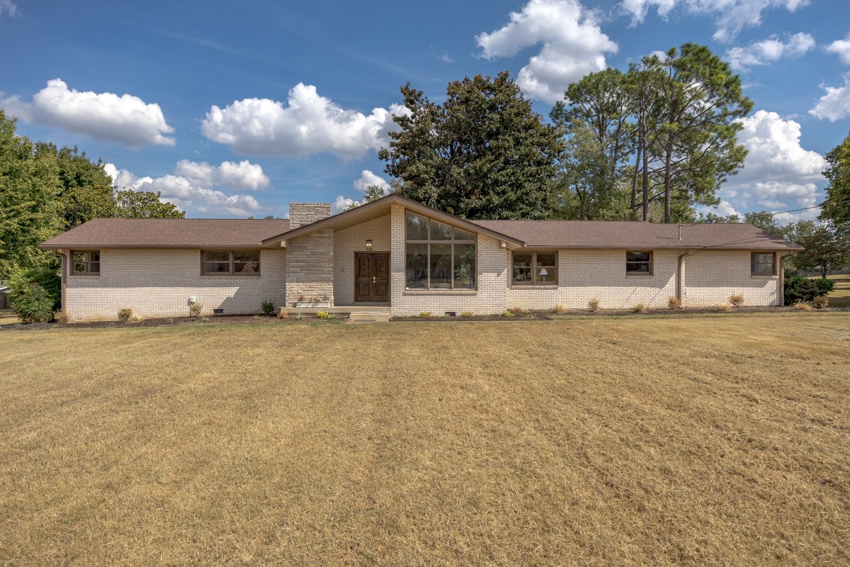 Single-story brick ranch home with a gabled entry and broad front lawn.