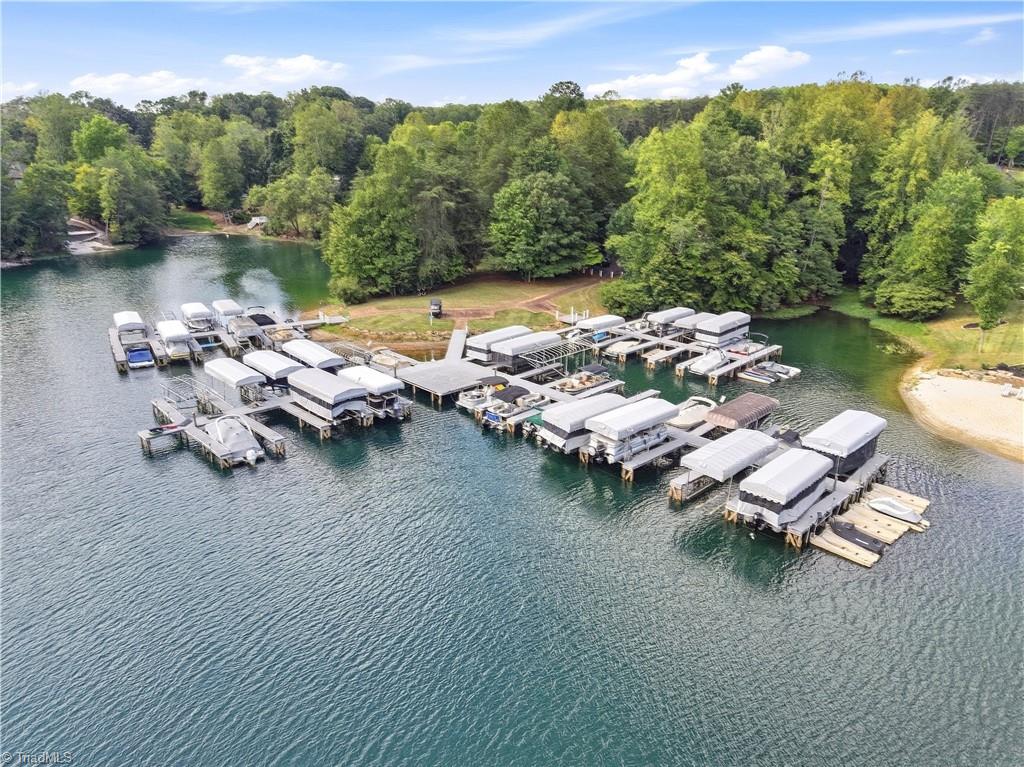 Aerial view of covered boat docks on a wooded lake shoreline.