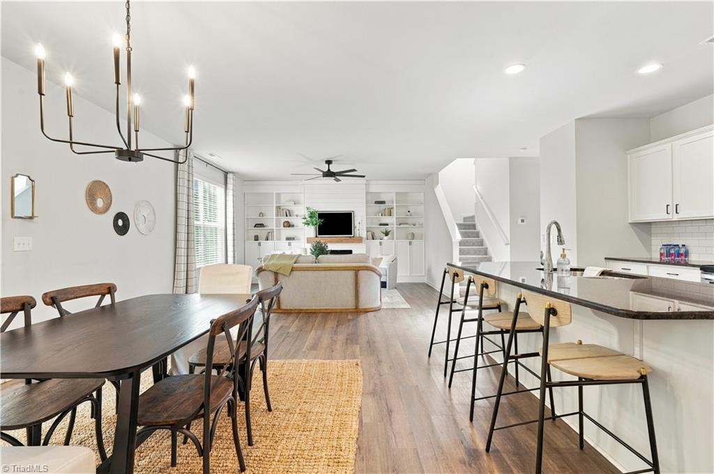 Open-plan kitchen, dining area, and living room with a large island and built-in shelves.