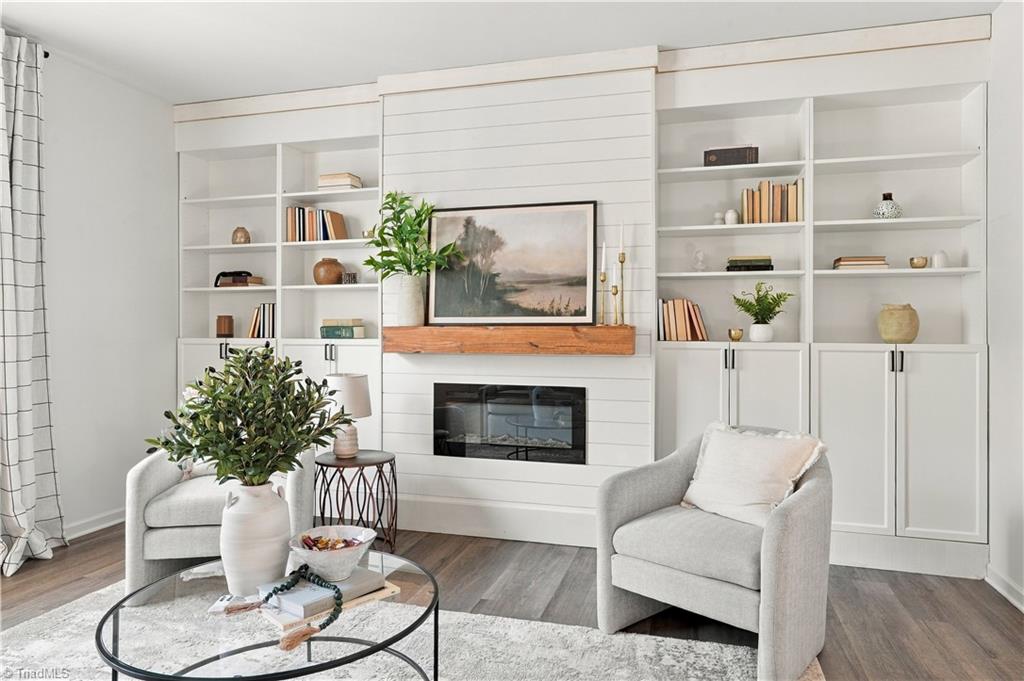 Living room with a shiplap fireplace, built-in shelves, and two light upholstered armchairs.