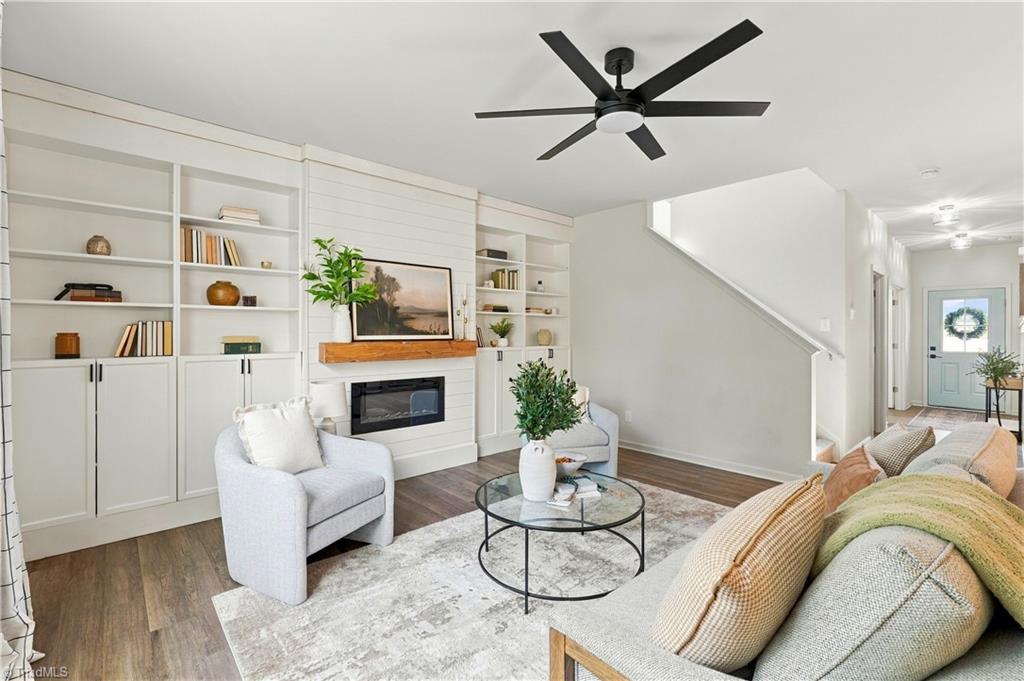Staged living room with built-in bookshelves, fireplace, and glass coffee table.