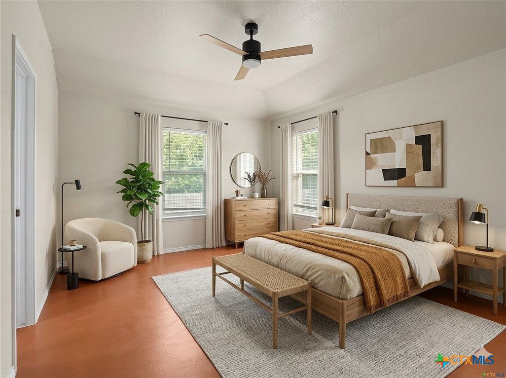 Staged bedroom with a wood bed, rust-colored throw, two curtained windows, and a ceiling fan.