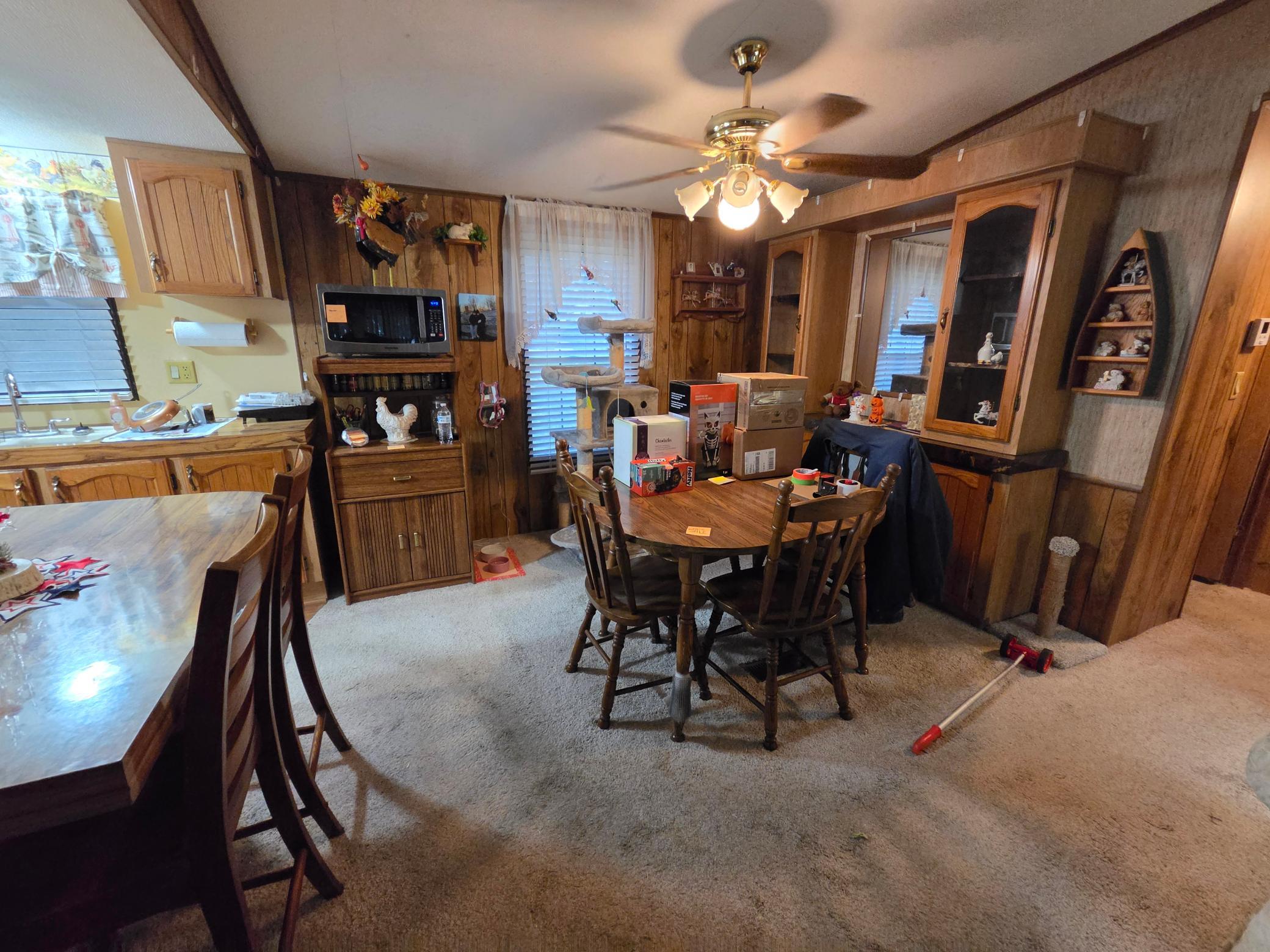 Dining area with wood-paneled walls, built-in cabinets, and a round table surrounded by chairs.