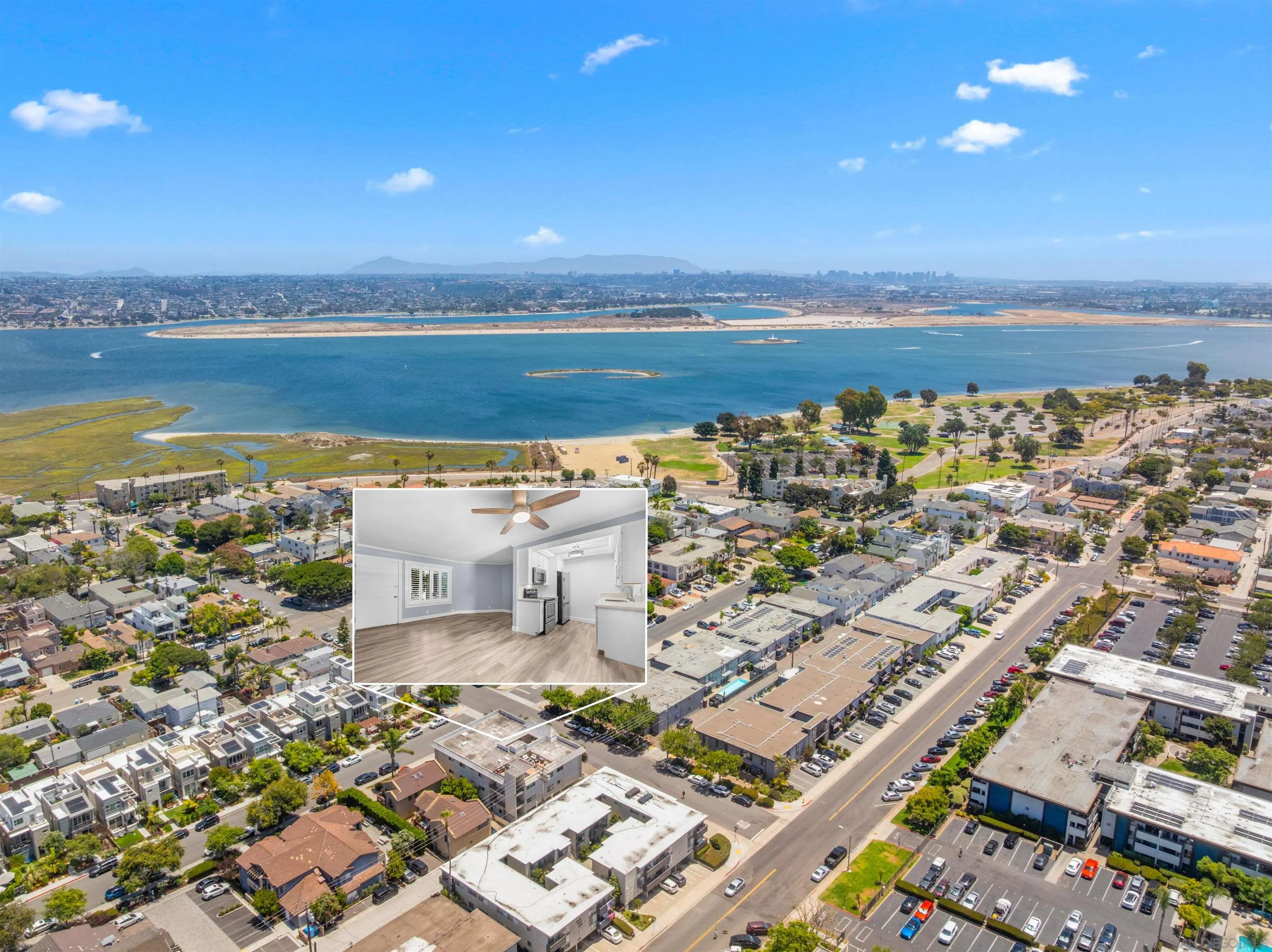 Aerial view of a coastal neighborhood and bay, with an inset of a vacant living area and kitchen.