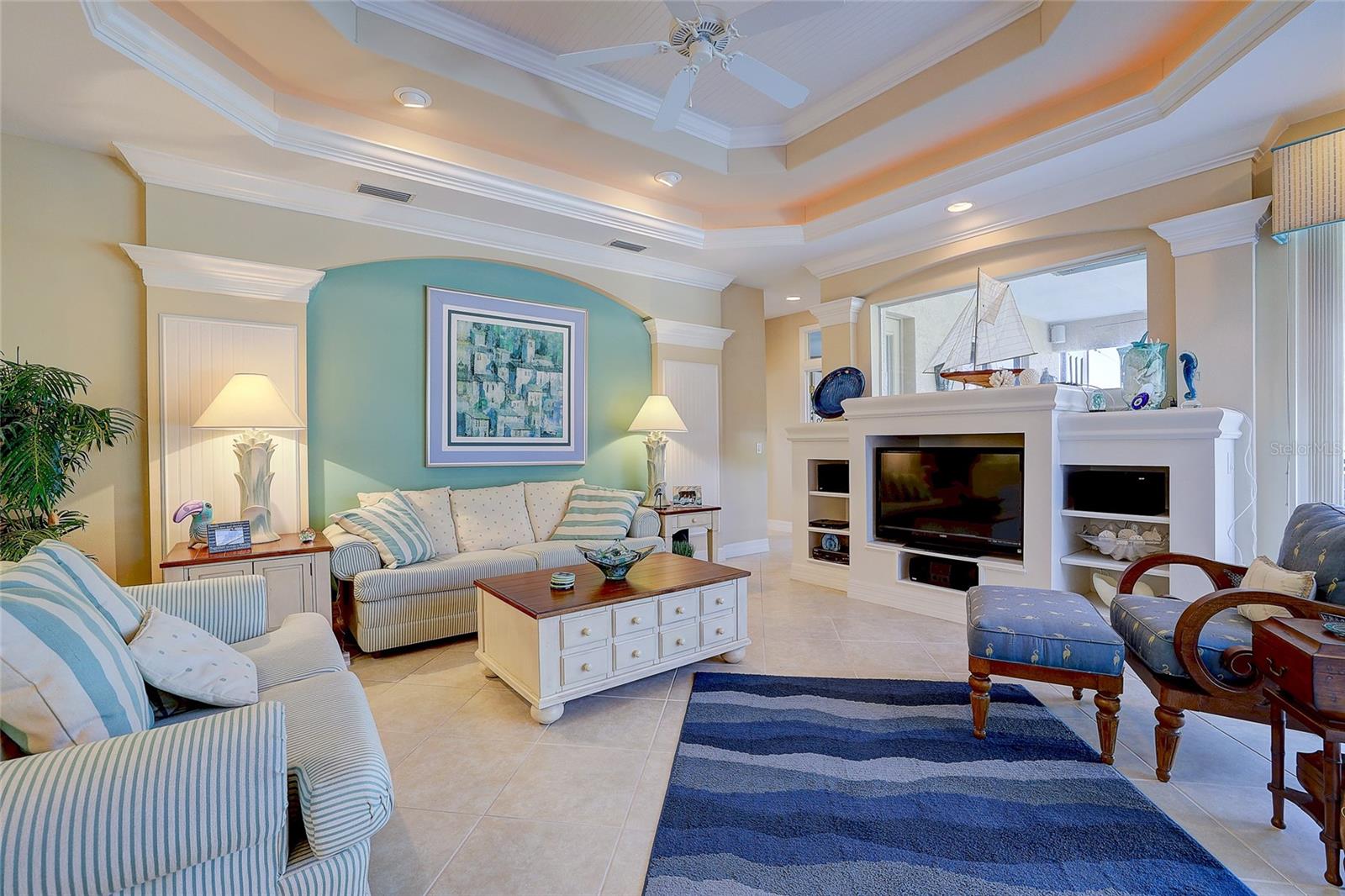 Living room with striped sofas, a blue accent wall, and a built-in entertainment center.