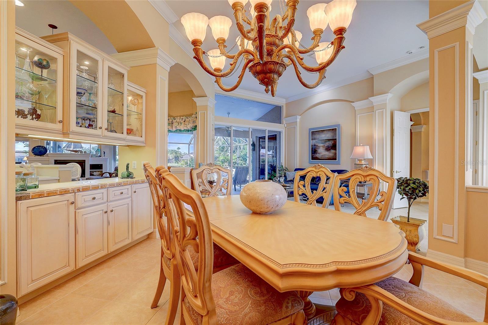 Dining room with an ornate table, glass-front cabinets, and sliding doors to the patio.