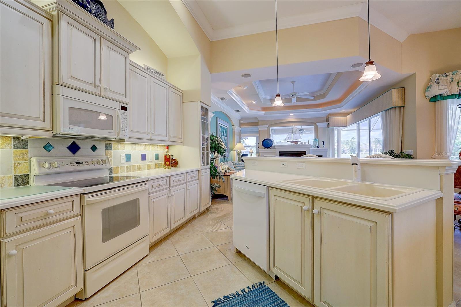 Cream kitchen with a large island, double sink, and open views into the living area.