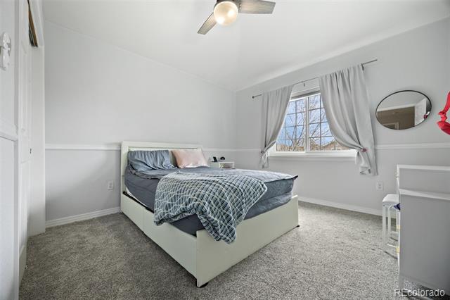 Furnished bedroom with blue-gray bedding, gray curtains, and a window.