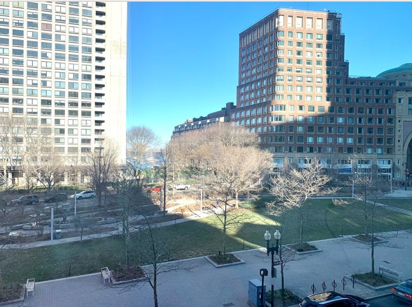 City plaza with bare trees and surrounding office buildings, viewed from above.