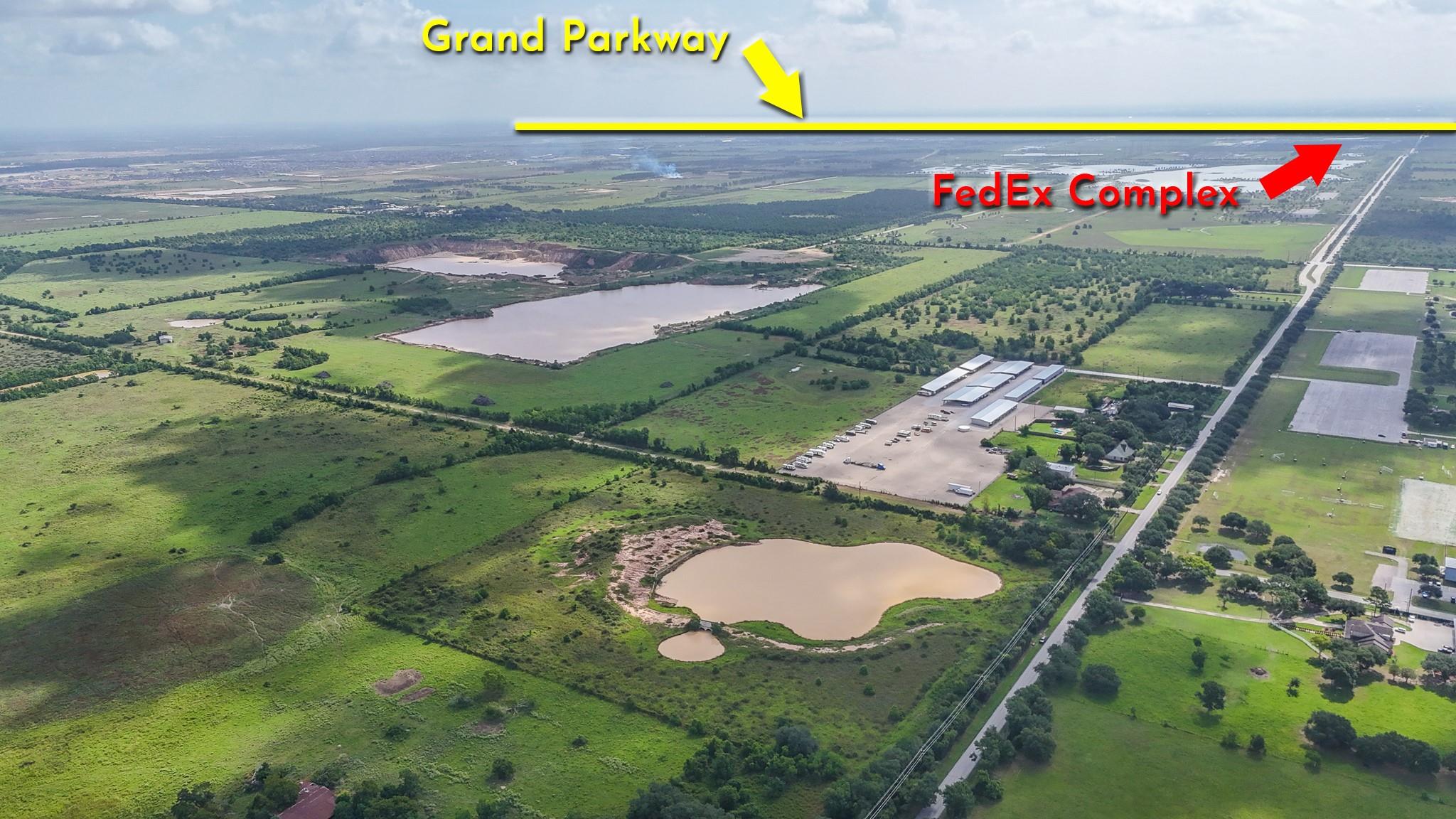 Aerial acreage with ponds, warehouses, and labels for Grand Parkway and FedEx Complex.