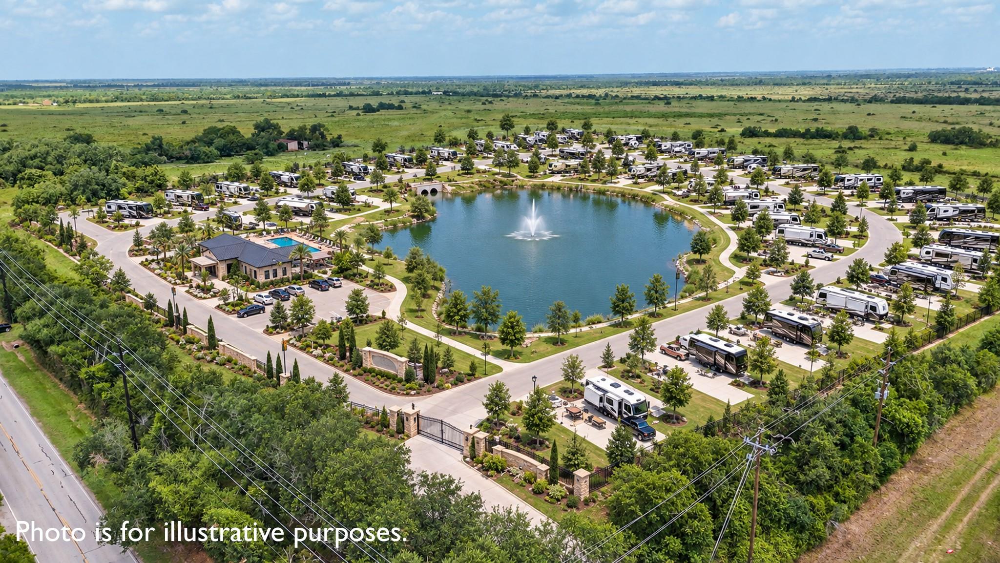Aerial view of an RV park surrounding a fountain pond, with a clubhouse and pool near the entrance.