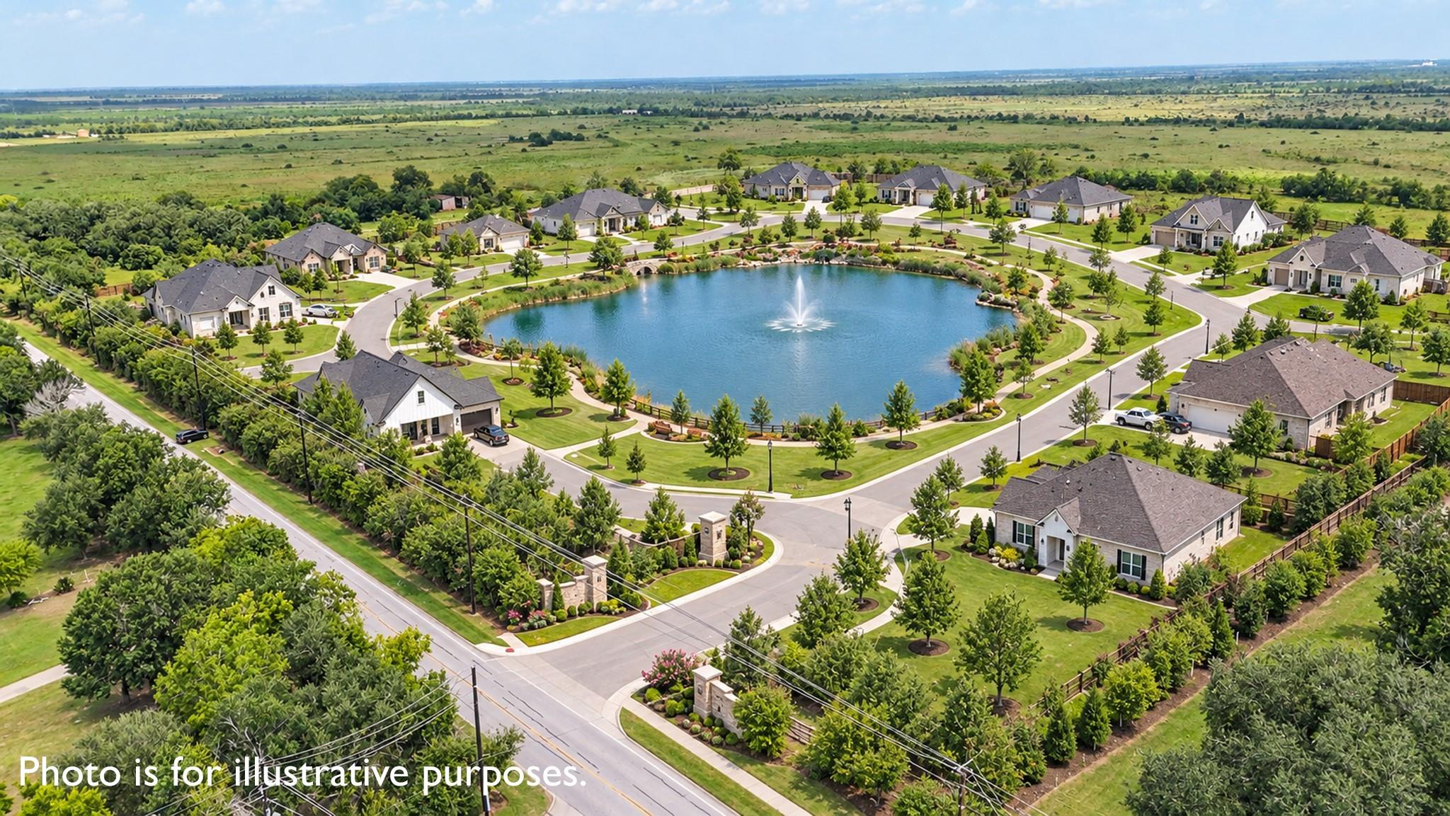 Aerial view of homes surrounding a landscaped pond with a central fountain.