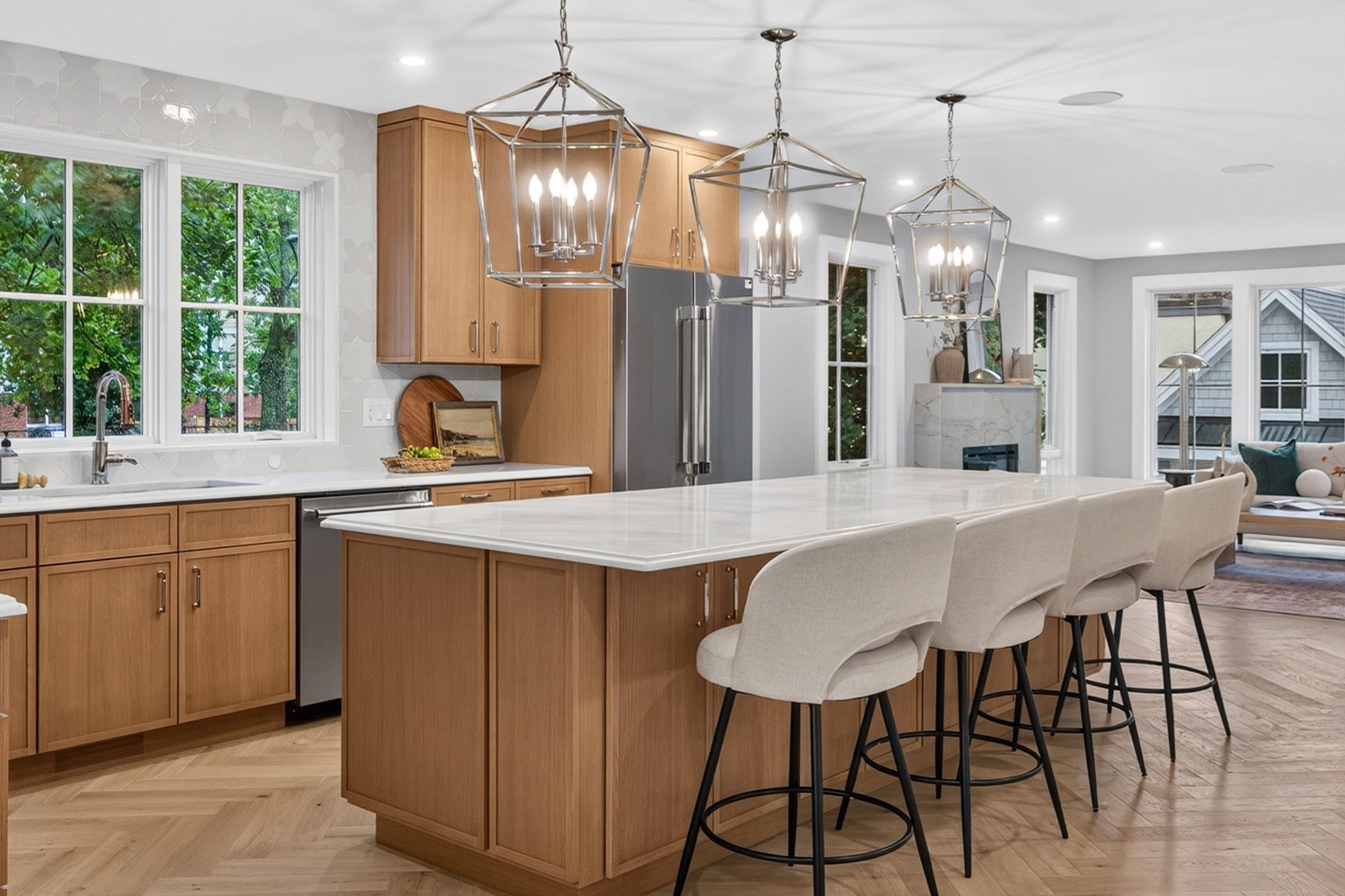 Kitchen with a large white island, warm wood cabinetry, and three geometric pendant lights.