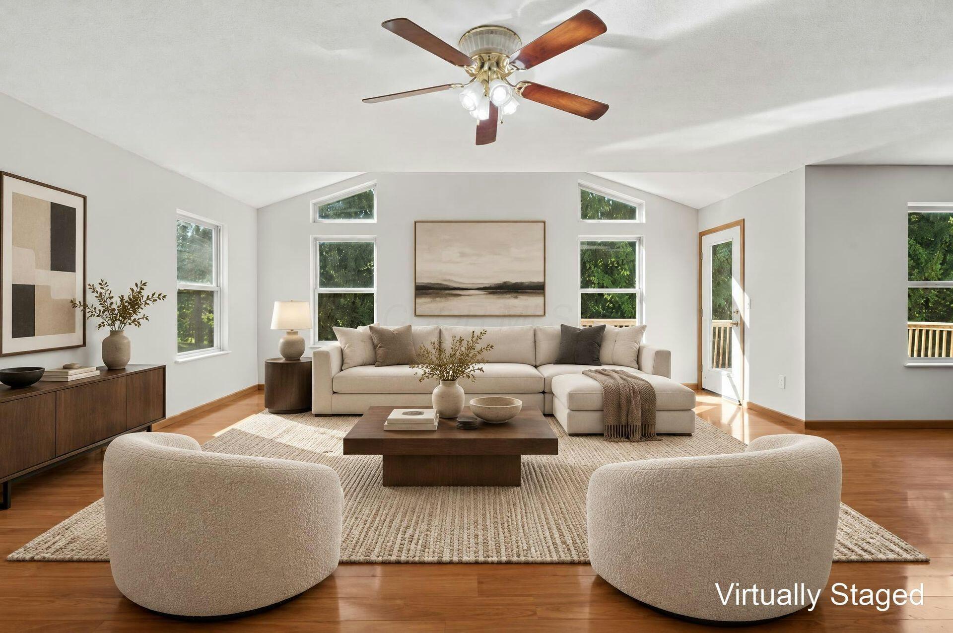 Virtually staged living room with a vaulted ceiling, large windows, and a cream sectional sofa.