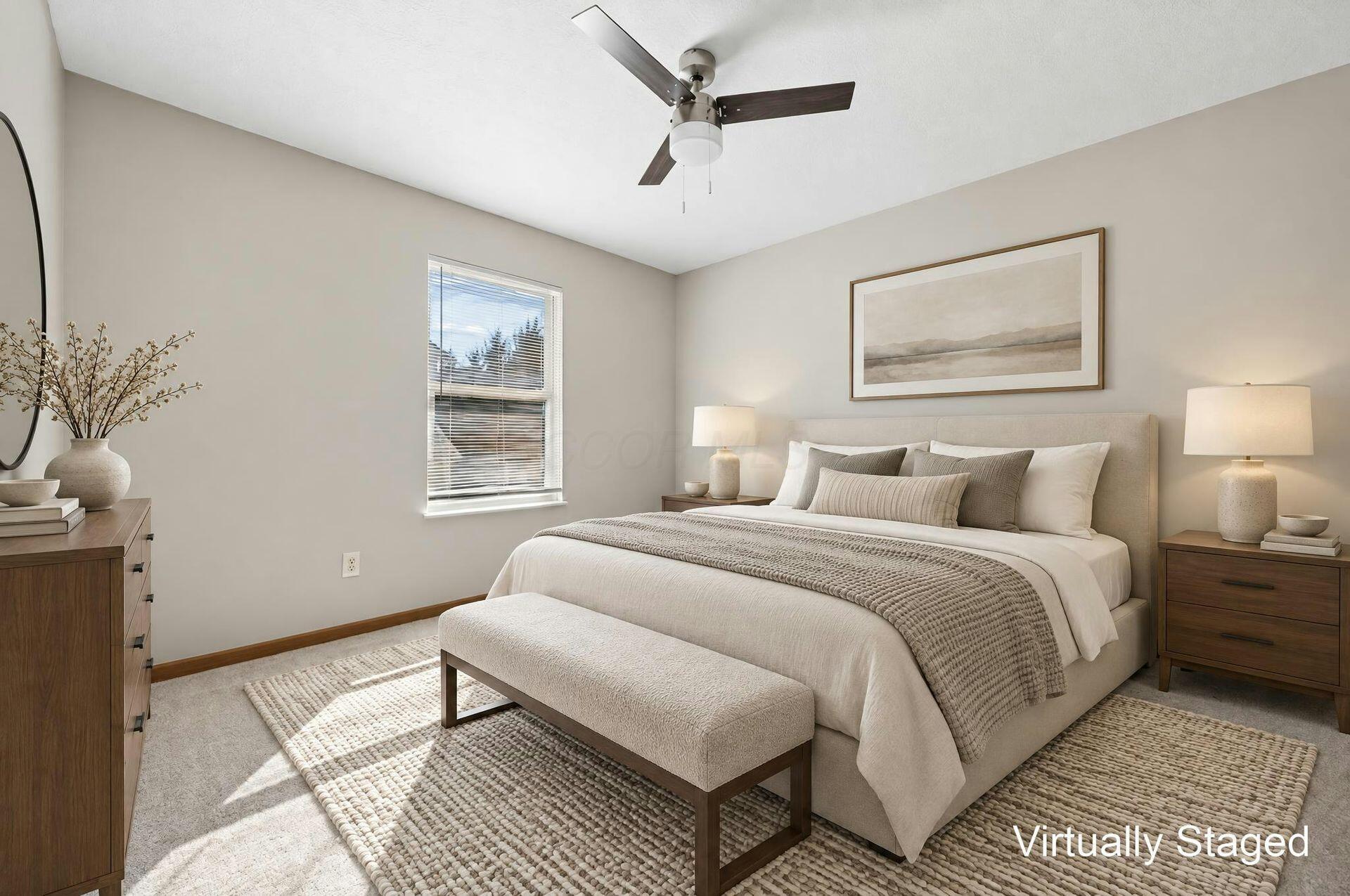 Virtually staged bedroom with a large upholstered bed, wood nightstands, and a ceiling fan.