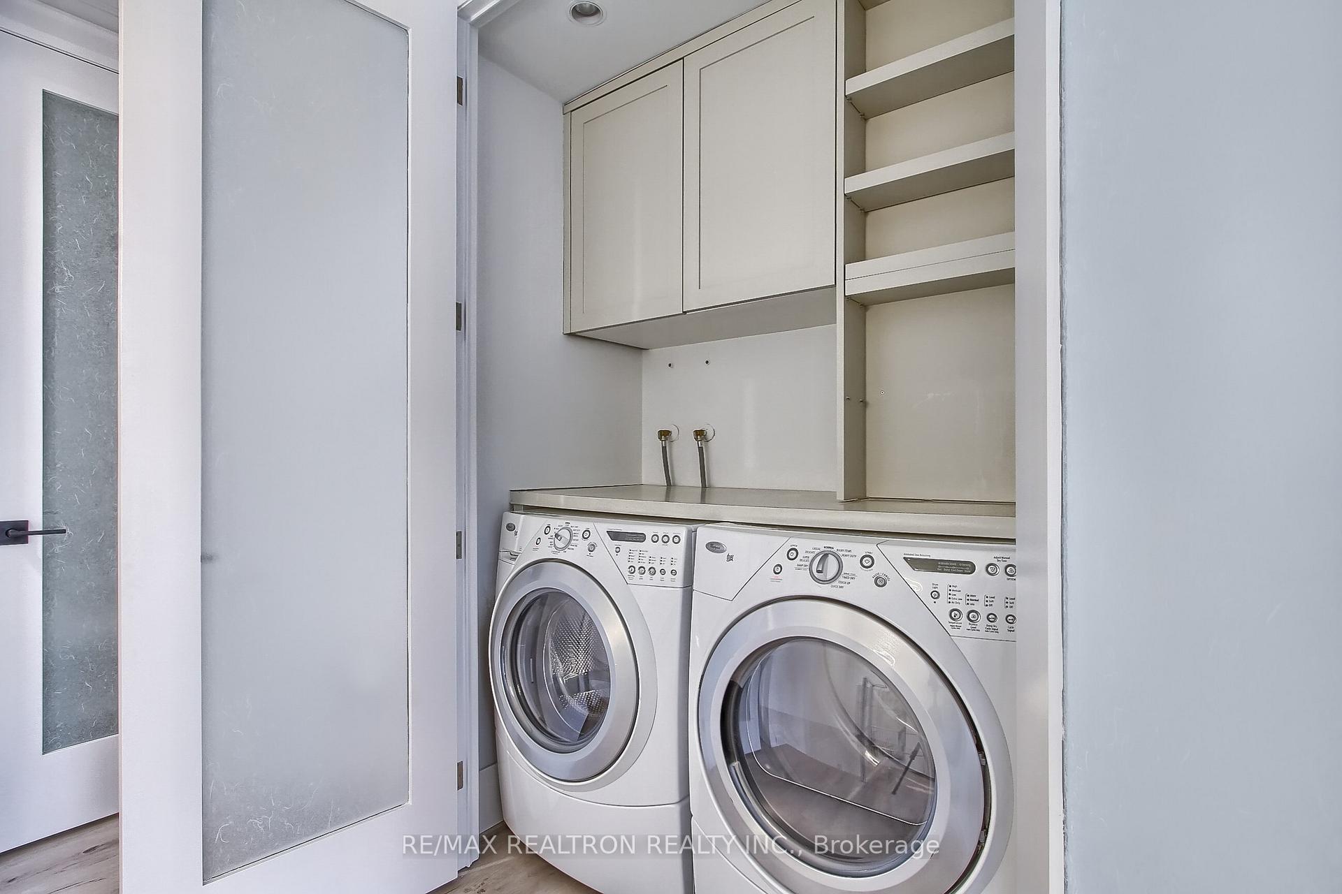 Laundry closet with front-loading washer and dryer, countertop, overhead cabinets, and open shelves.