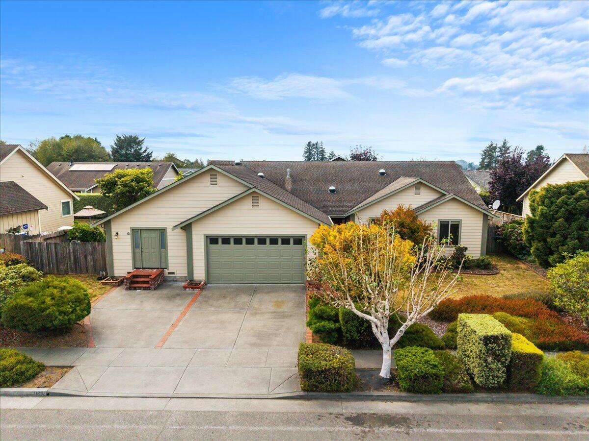 Single-story home with attached two-car garage, broad driveway, and landscaped front yard.