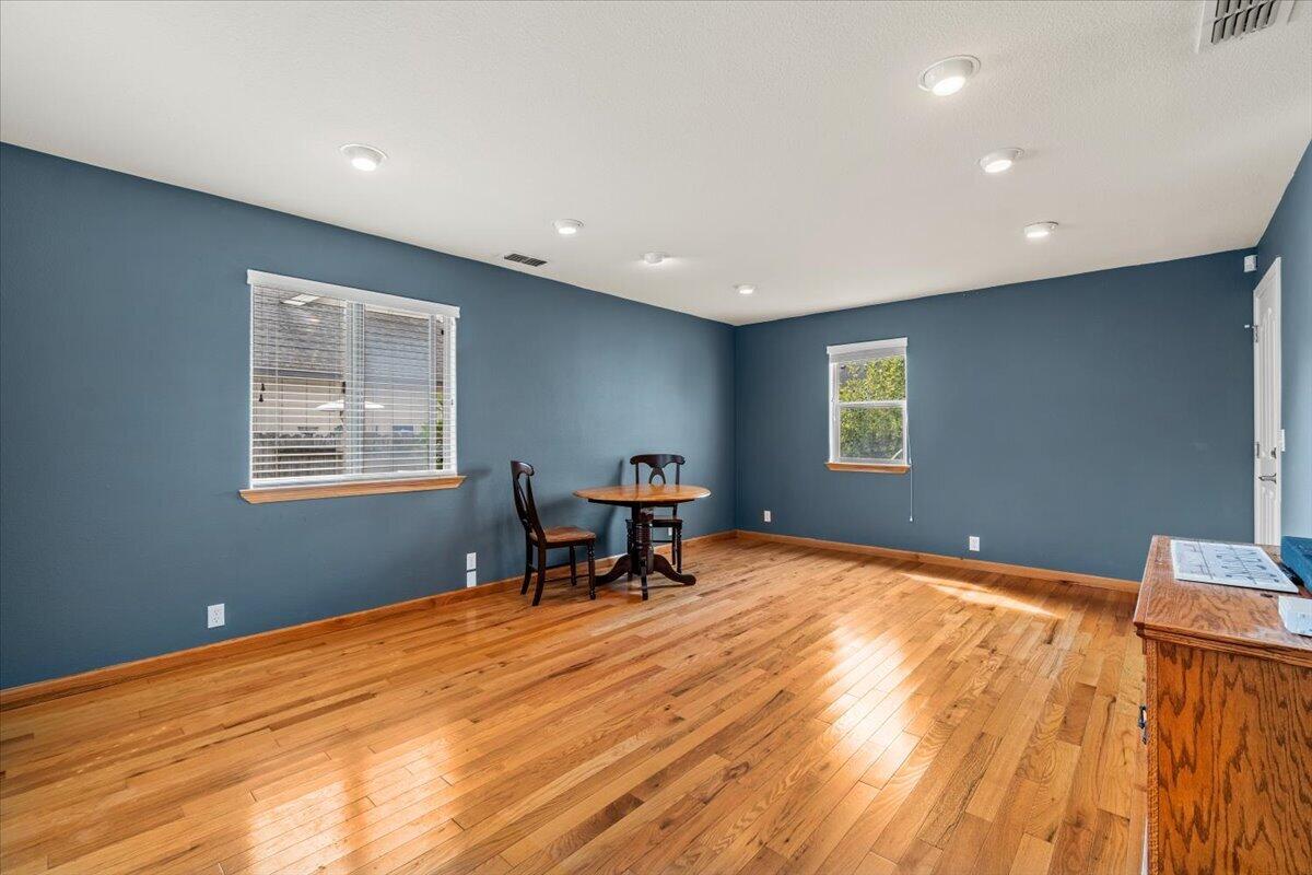 Dining room with blue walls, hardwood floors, and a small table and chairs.