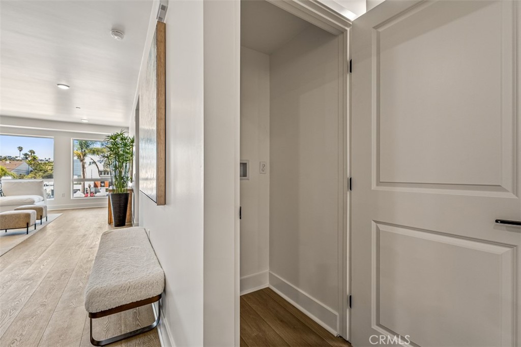 Condo entry hall with a built-in bench and bright living area beyond.