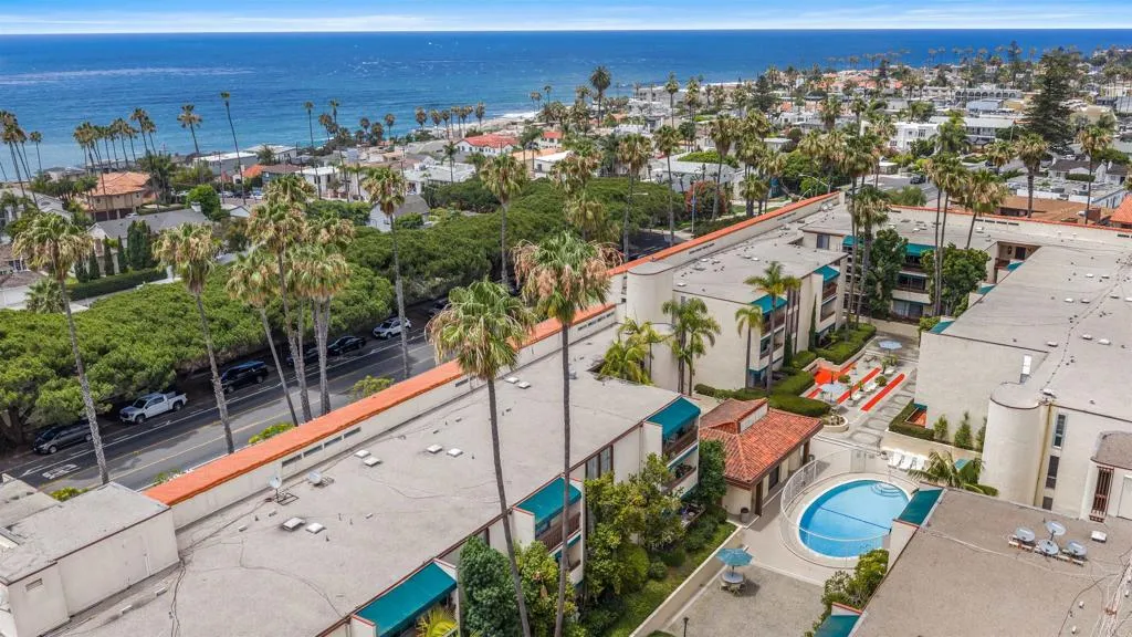 Aerial view of a La Jolla condo complex with a courtyard pool and the Pacific Ocean beyond.