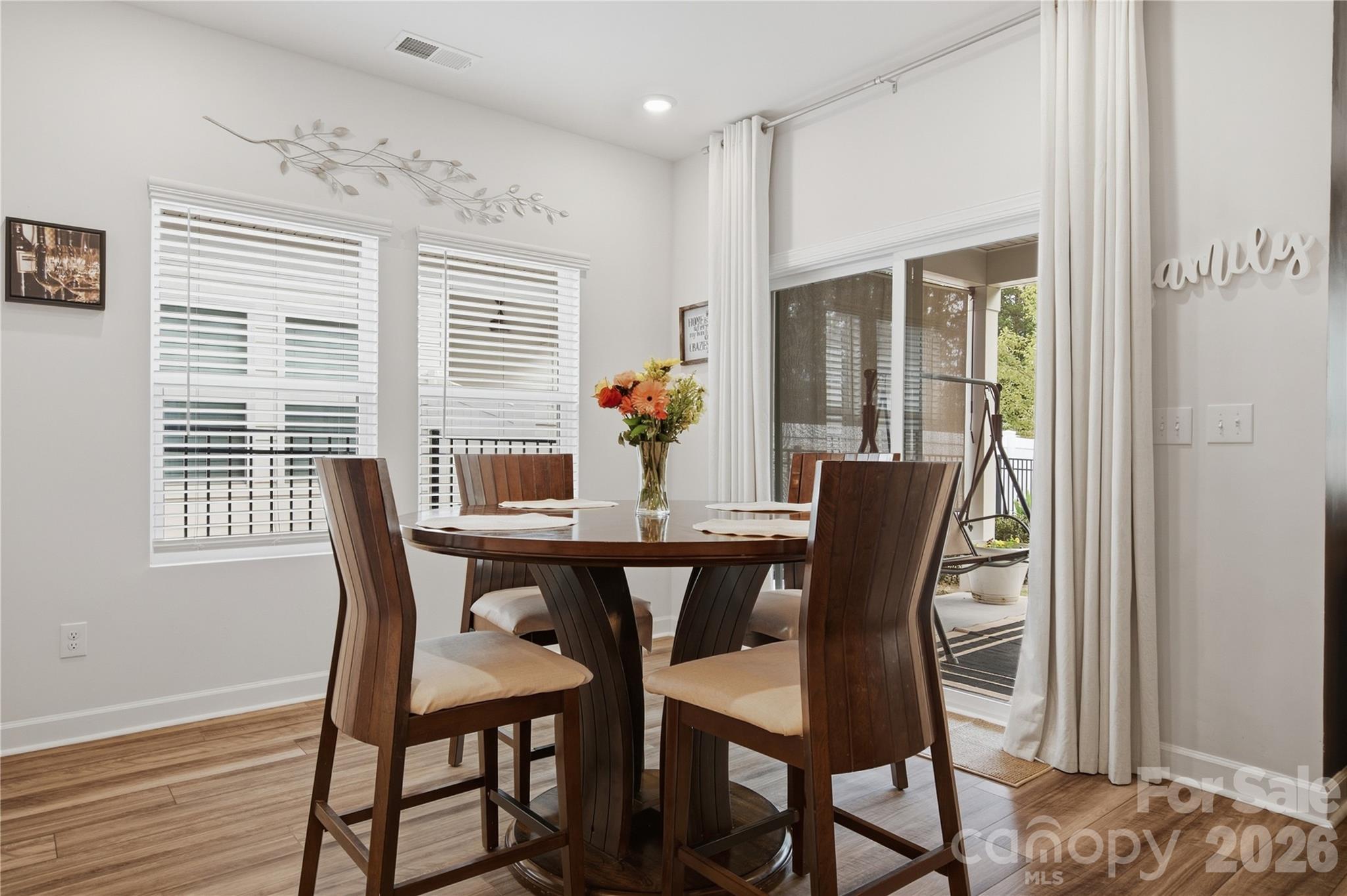 Dining room with a dark wood table, four chairs, and sliding glass doors to a patio.