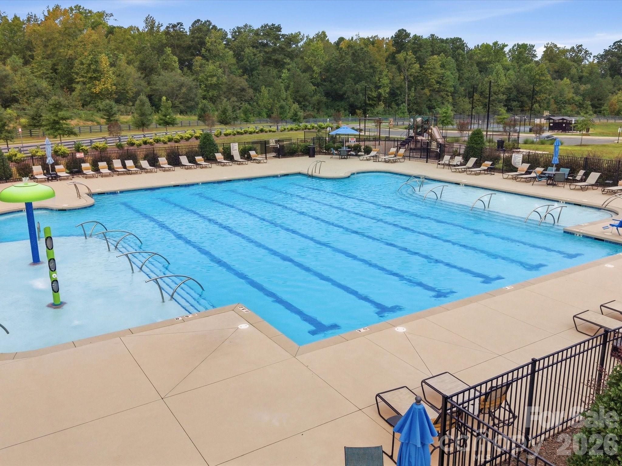 Community pool with lap lanes, a shallow splash area, and lounge chairs around the deck.