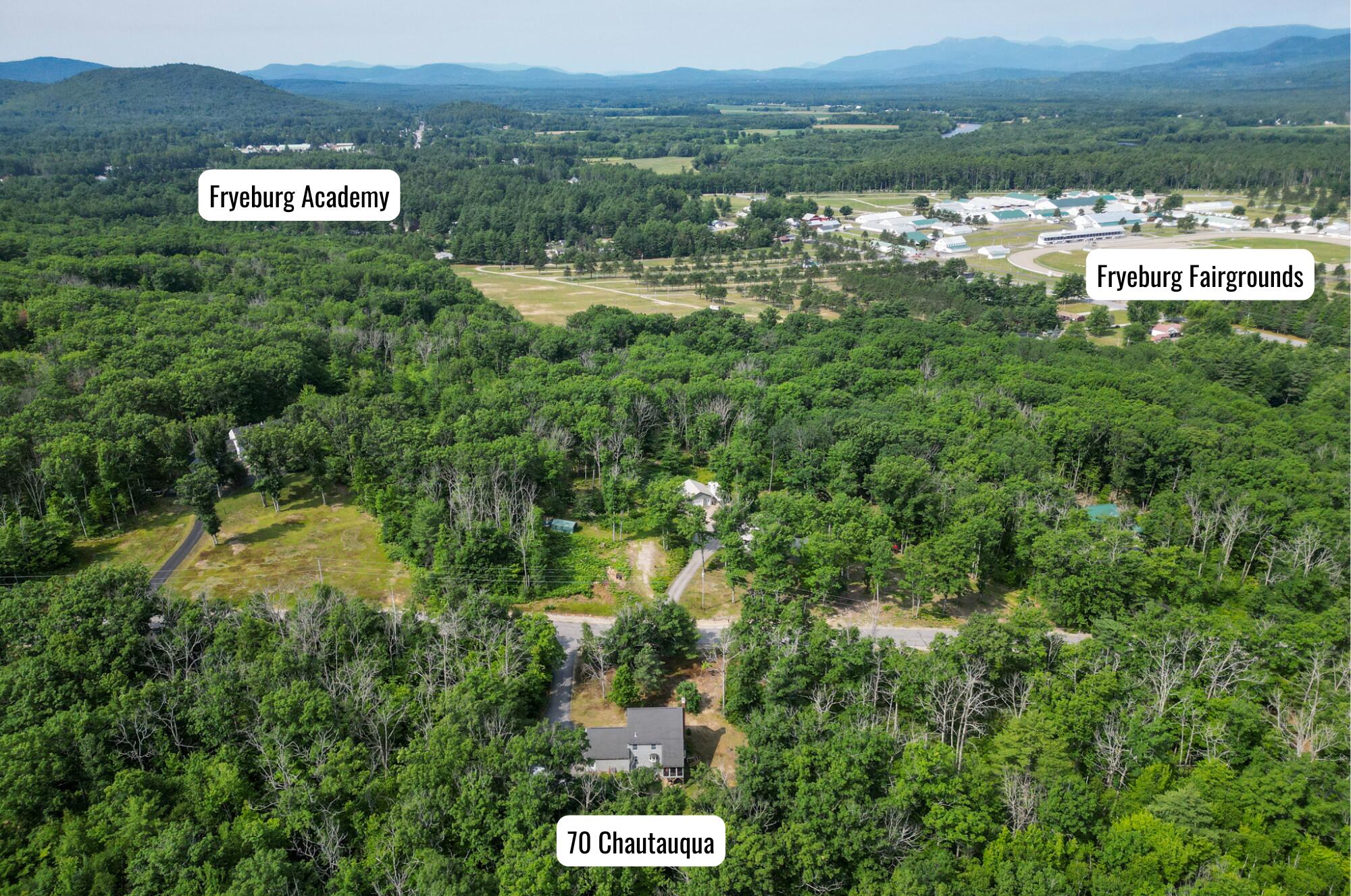 Aerial view of 70 Chautauqua Road amid forest, with Fryeburg Academy and Fryeburg Fairgrounds nearby.