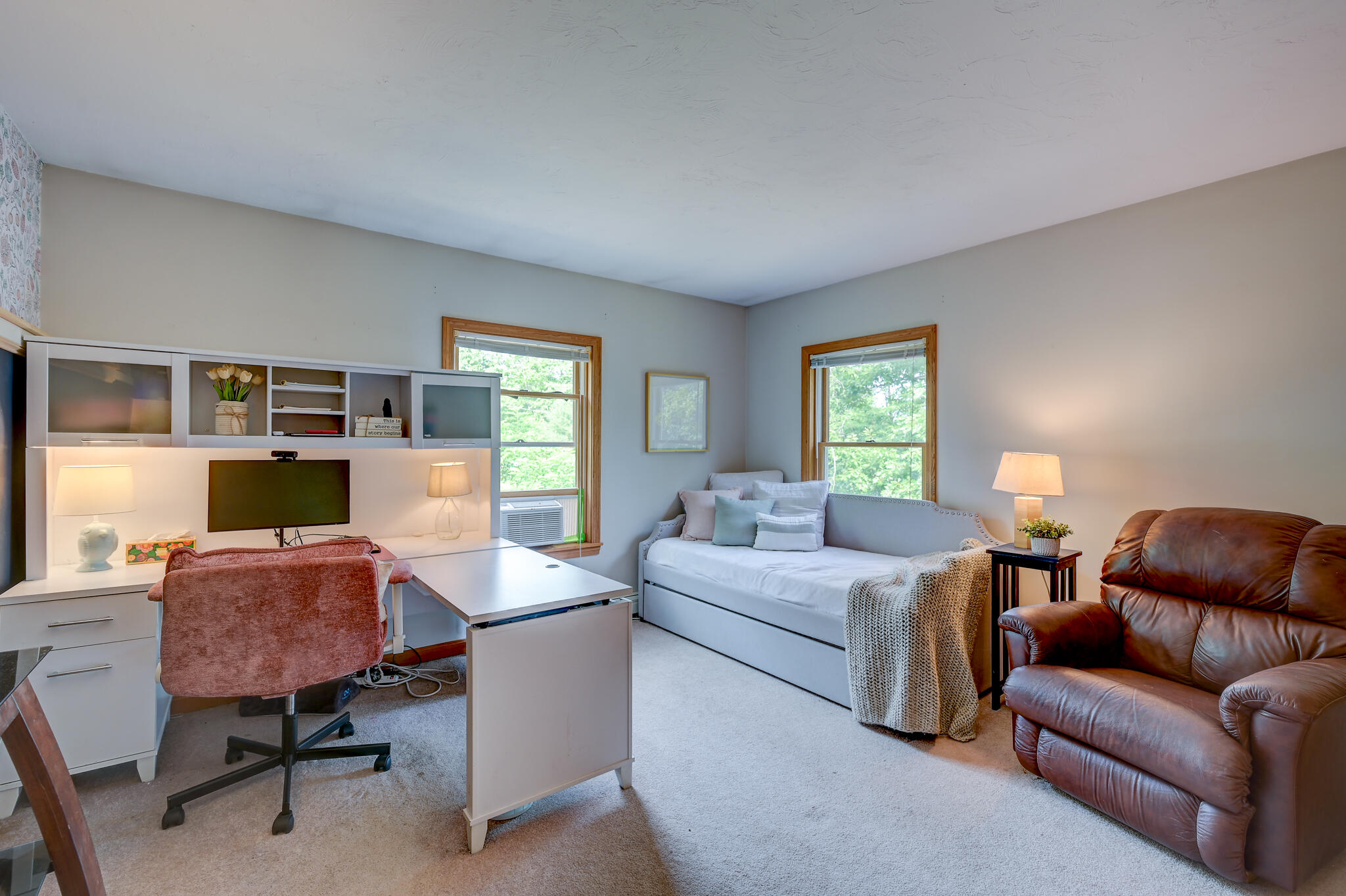 Furnished living room and office with built-in desk, daybed, and leather recliner.