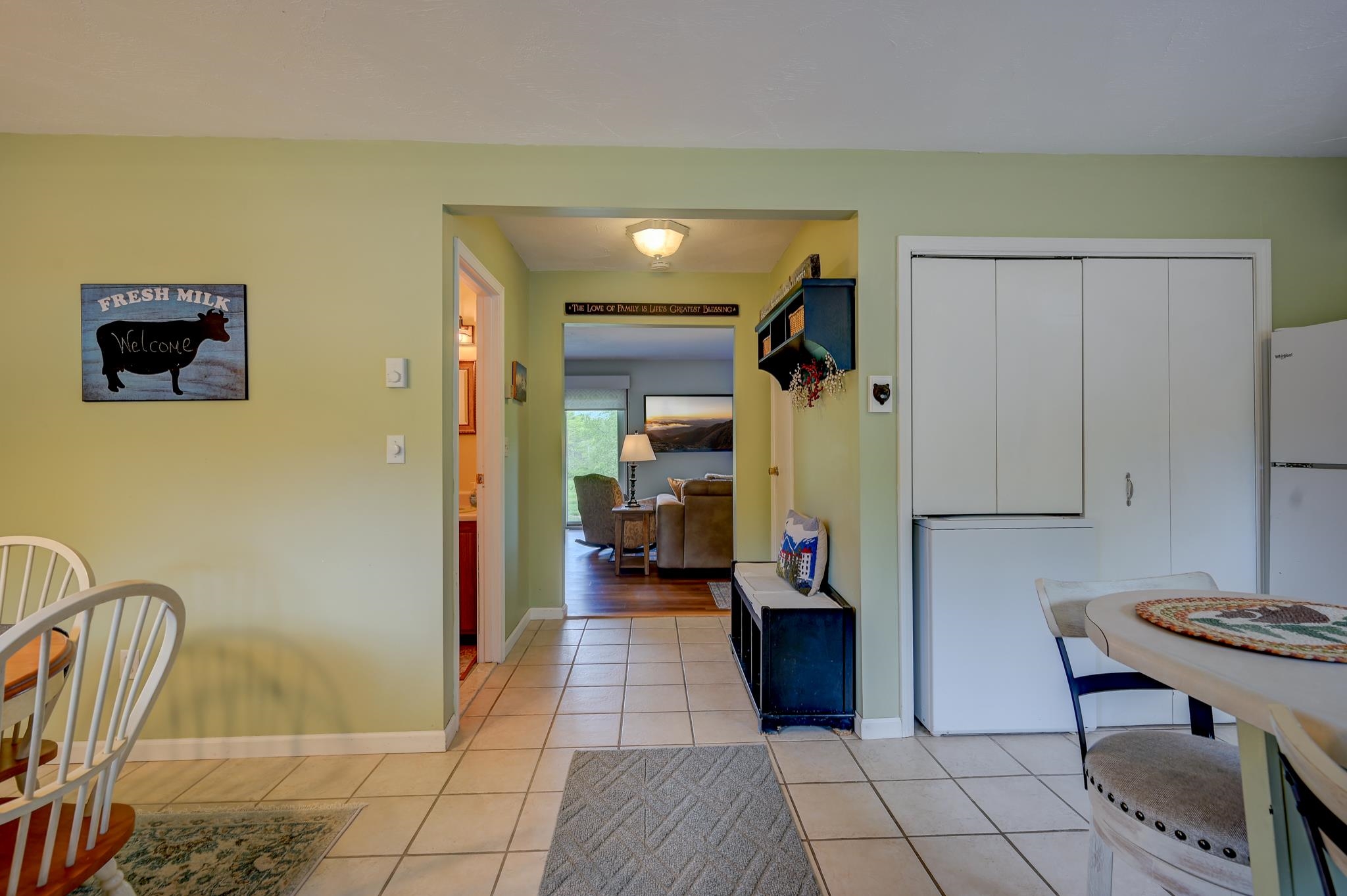 Furnished kitchen and dining area with tiled floors and an open view into the living room.