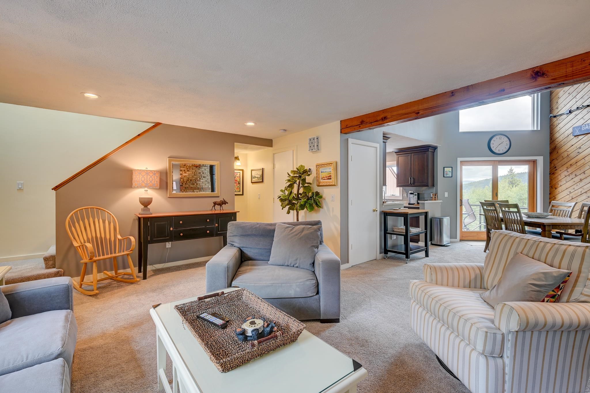 Living room with gray seating, a rocking chair, and mountain views through the sliding doors.