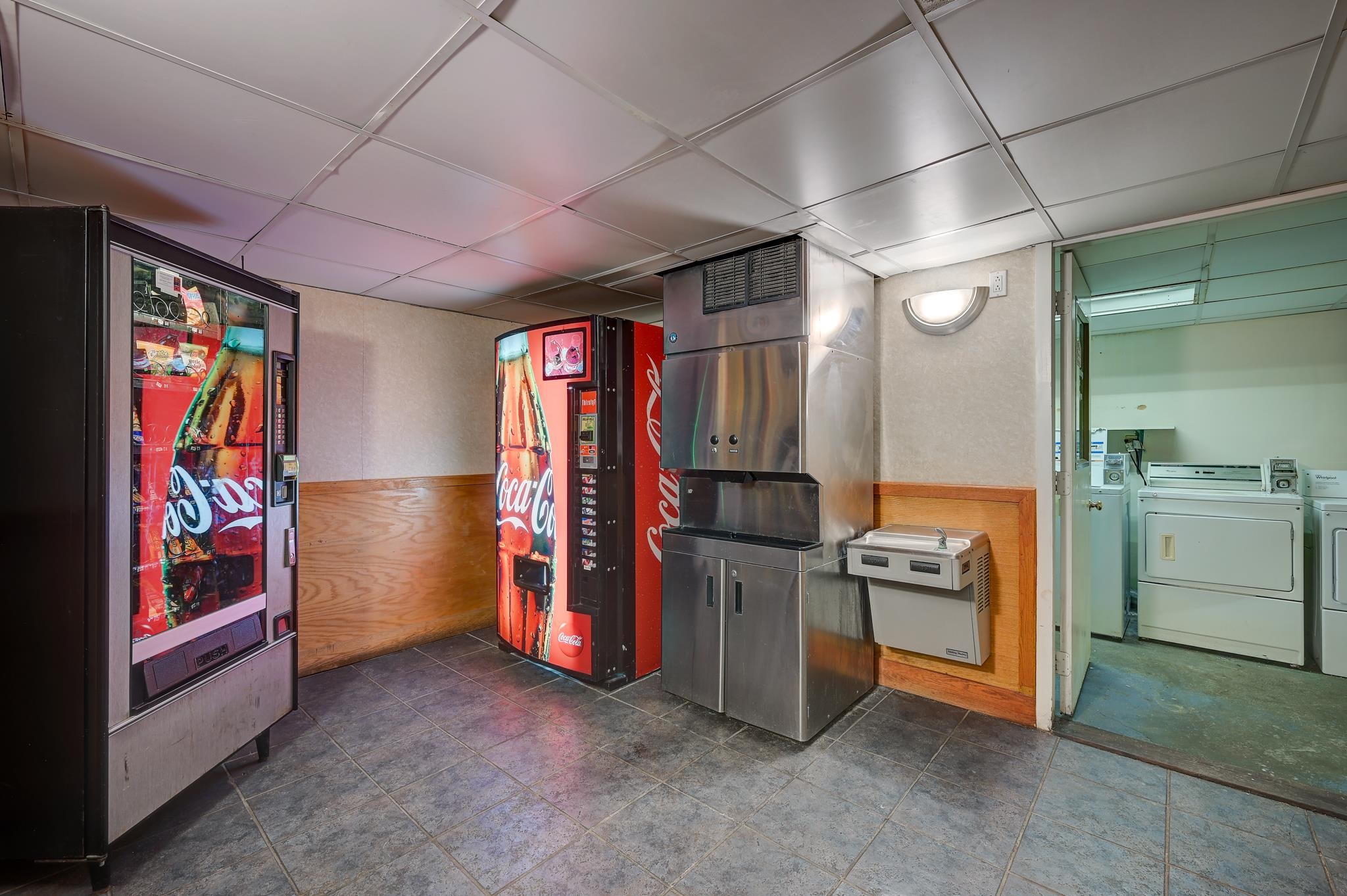 Communal laundry room with Coca-Cola vending machines and washers and dryers.