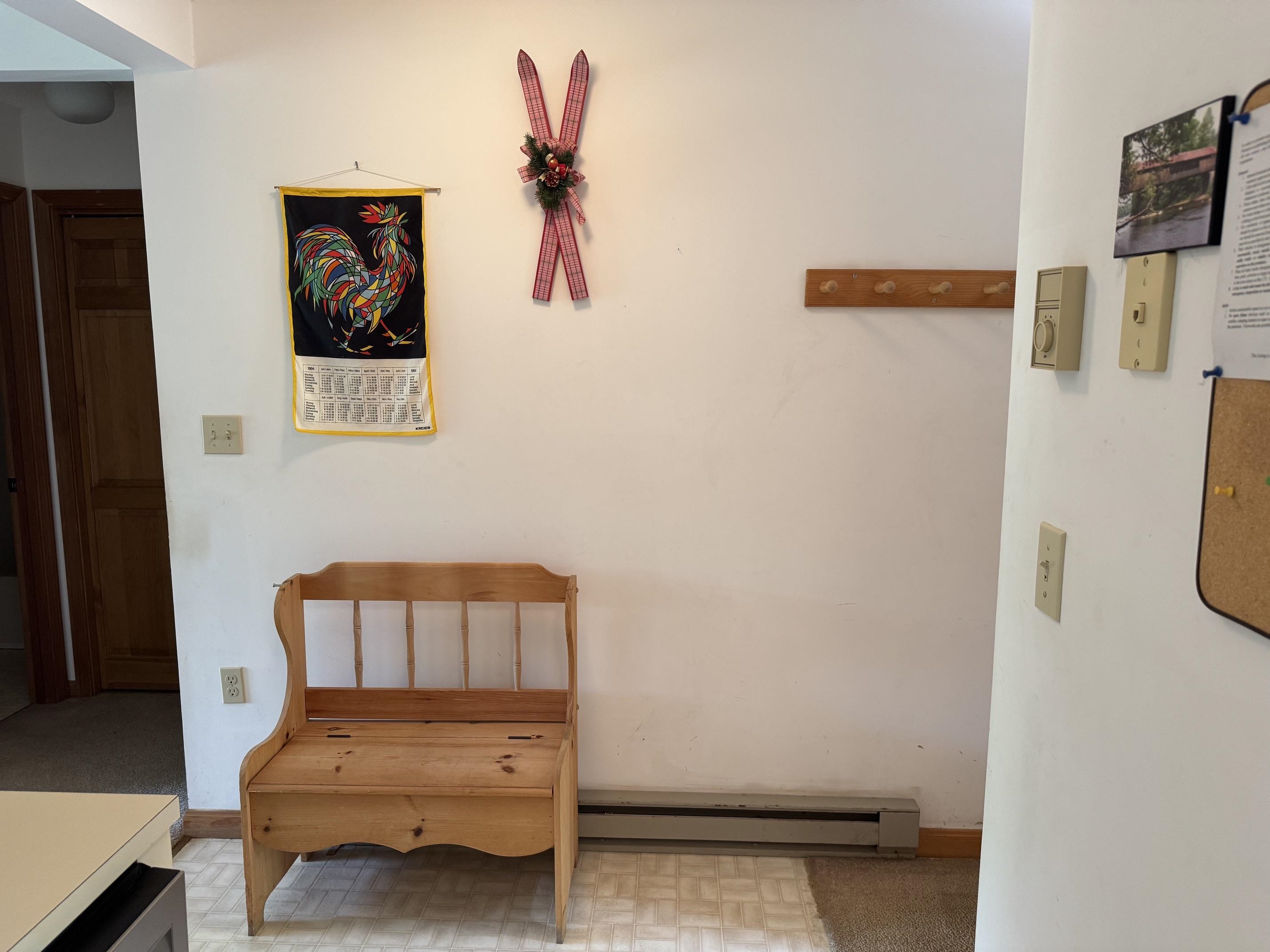 Entry area with a wooden bench, coat hooks, and ski decorations.