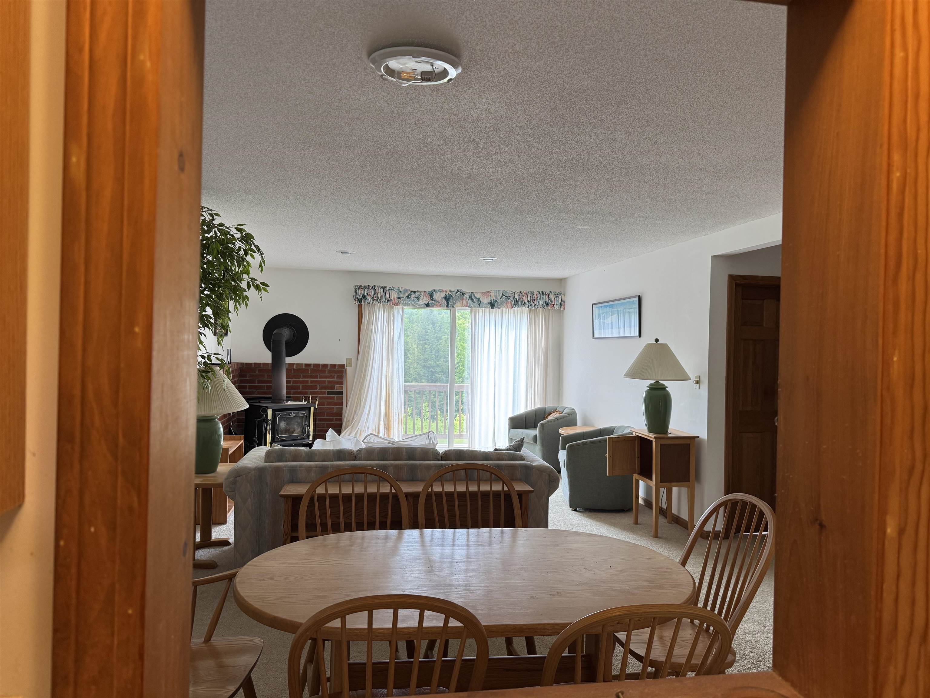 Living and dining room with a wood stove, sliding glass doors, and a round dining table.